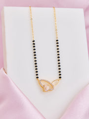 Necklace with black beads and gold clasp on a pink satin surface