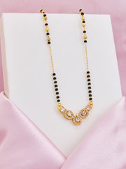 Necklace with black and gold beads on a pink satin surface