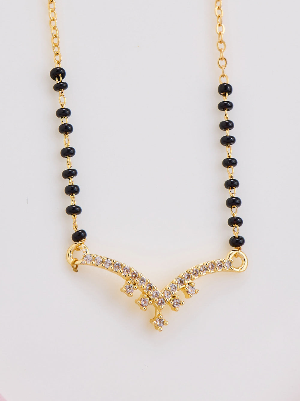 Necklace with black beads and gold clasp on a white background