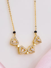 Gold necklace with triangular pendants on a light pink background