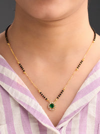Necklace with a green pendant worn by a person in a striped shirt