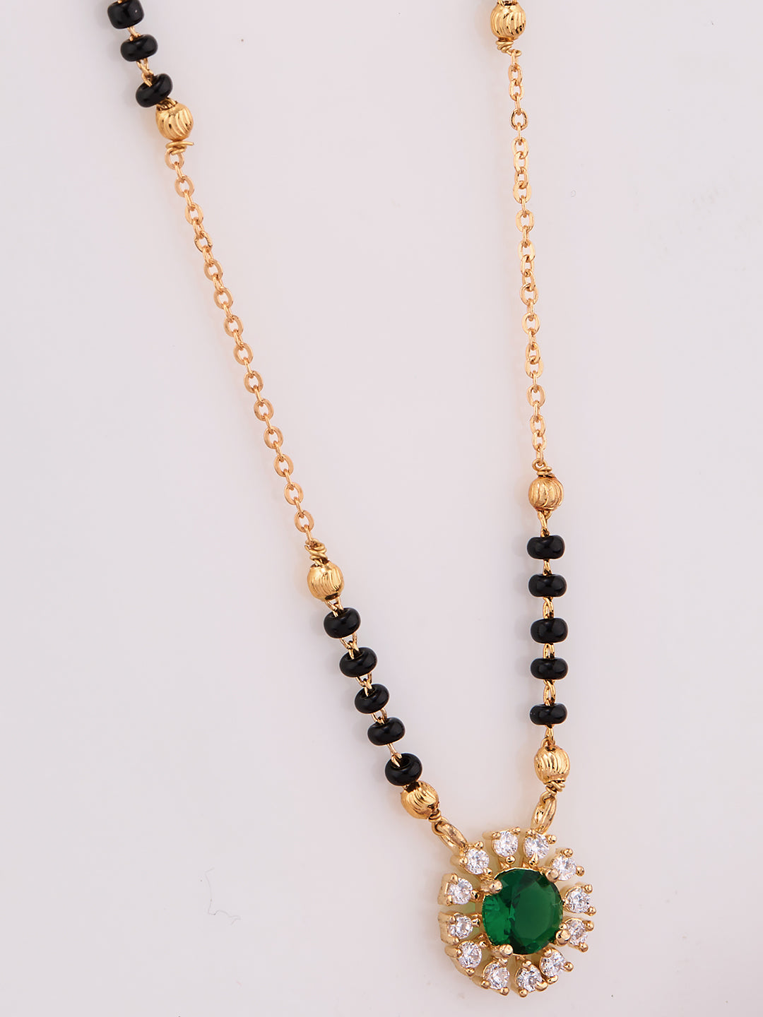 Necklace with green gemstone pendant and black beads on a white background