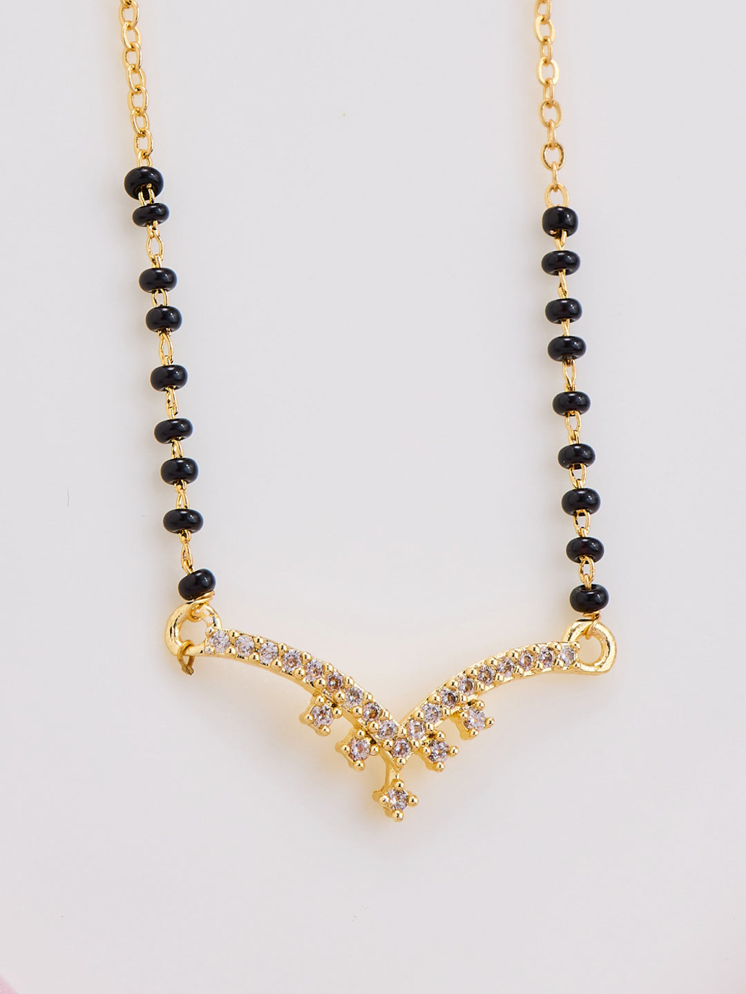 Necklace with black beads and gold clasp on a white background