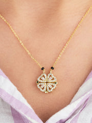 Gold necklace with a heart-shaped pendant on a person wearing a light-colored top.